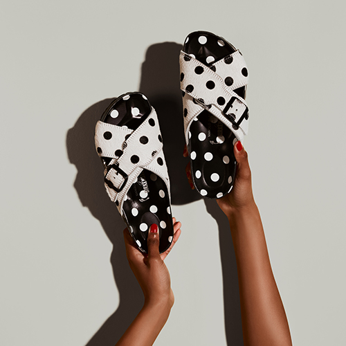 A hand holding the Manolo Blahnik x Birkenstock polka dot Rodra