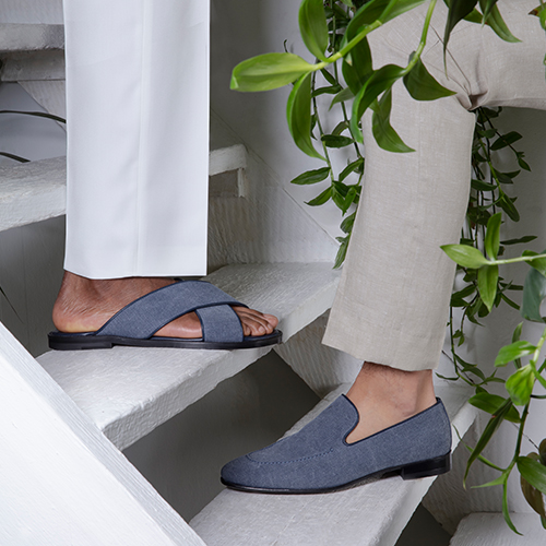 Two men standing on steps; one is wearing a denim sandal and the other is wearing a denim loafer.