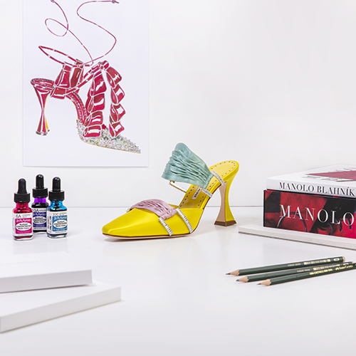 The Chinci surrounded by pencils, a Manolo Blahnik sketch, paint and Manolo Blahnik books