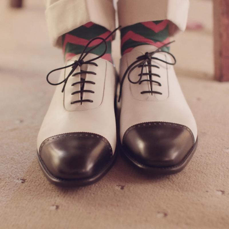 A pair of black and white leather oxford shoes