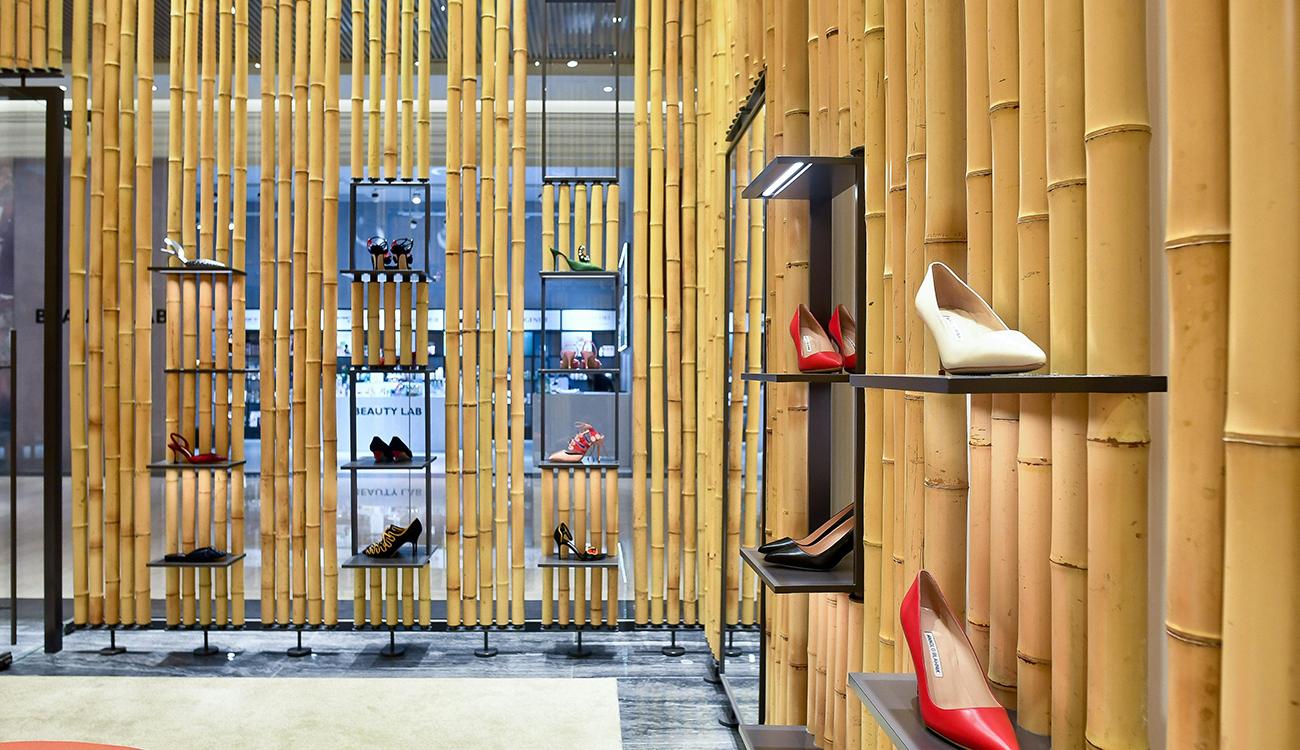Internal view of the Taiwan store. The walls are clad with bamboo, there are small shelves with shoes on them. 