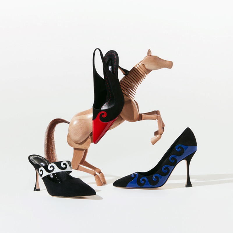 Wooden horse with pumps with white scroll design, black suede pumps with blue scroll design and black pumps with red scroll design