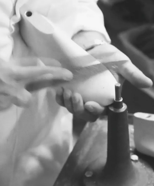 A still from the ‘Manolo at Work’ video. A close up of Manolo’s hand holding a wooden shoe last.